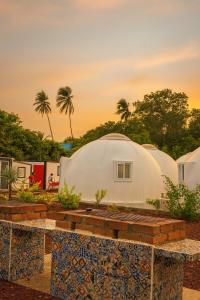 a dome house with a patio and palm trees at Apple House cerca de la playa in Barra de Navidad