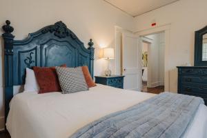 a bedroom with a large bed with a blue headboard at Historic Revival 2BR Midtown Memphis Fast Wifi Free Parking Yes Pets in Memphis