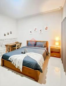 a bedroom with a bed and a table in it at Uluwatu Guest House B Pool & Wifi in Uluwatu