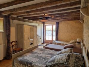 a bedroom with two beds and a window at Chambre cosy au cœur du Berry avec petit-déjeuner maison - FR-1-591-693 in Thevet-Saint-Julien