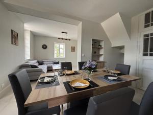 a dining room with a wooden table and chairs at Gîte familial au cœur de l'Allier, proche du PAL - FR-1-489-587 in Saligny-sur-Roudon