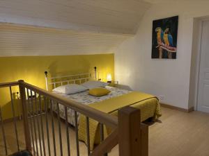 a bedroom with a bed with a yellow bedspread at Maison calme à Bransat, climatisée et avec jardin pour 6 personnes - FR-1-489-588 in Bransat