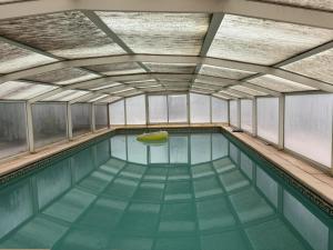 una piscina con un barco amarillo en el medio en Gîte De Fontariol avec Piscine Couverte en Auvergne - FR-1-489-590, en Le Theil