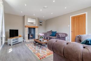 a living room with two couches and a fireplace at Rectory Lodge - Norfolk in Oxborough