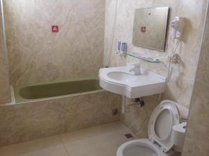 a bathroom with a sink and a toilet and a tub at KD Hotel in Douliu