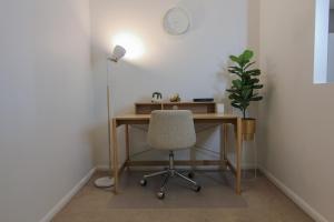 escritorio con silla y reloj en la pared en Open 1 Bedroom Apartment in Brisbane City, en Brisbane