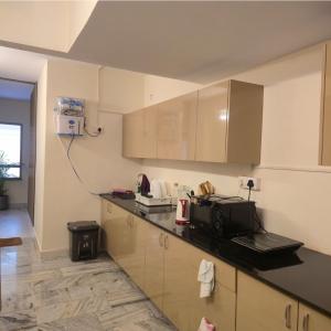 バンガロールにあるSuite 001の電子レンジ付きのカウンタートップを備えたキッチン +3枚の写真