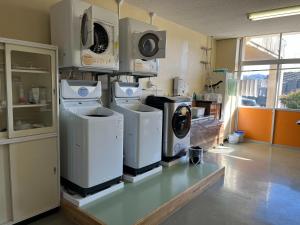 a laundry room with four washer and dryers on display at 三陸アクティブ in Ōfunato