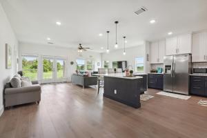 a large kitchen and living room with stainless steel appliances at Modern Farmhouse in McDade in McDade