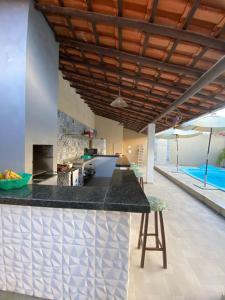 una cucina con bancone e una piscina di Tolentino - Casa de Praia a Santa Cruz Cabrália