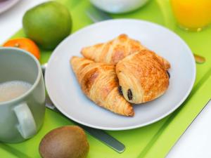 a plate of pastries on a table with a cup of coffee at ibis Styles Caen Centre Historique in Caen