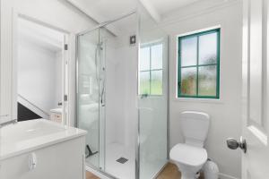 Waipu CoveにあるCove Family Haven - Waipu Holiday Homeのシャワーとトイレ付きの白いバスルーム +22枚の写真
