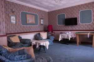 a living room with chairs and a tv on a wall at Raynscourt Lodge in Great Yarmouth