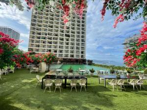 a hotel yard with tables and chairs and a building at Gold Coast Apartment Nha Trang in Nha Trang