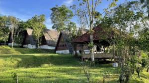 a house with a bench in the grass at Mountain View Eco Lodge in Kubupenlokan