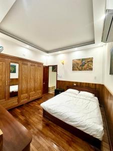 a bedroom with a large bed and wooden floors at Mây Homestay in Quy Nhon