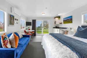 Un dormitorio con una cama grande y un sofá azul. en Matamata Lodge, en Matamata