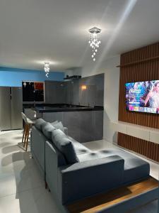a living room with a couch and a tv at House in Itacaré in Itacaré
