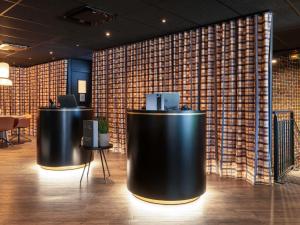 a lobby with two black tables and a wall at Novotel Bordeaux Centre Ville in Bordeaux