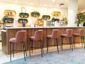 a row of stools in front of a bar at Mercure Paris Val de Fontenay in Fontenay-sous-Bois