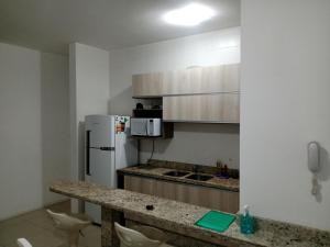 una cucina con bancone e frigorifero bianco di Deixe a energia fluir e contaminar suas férias. a Florianópolis