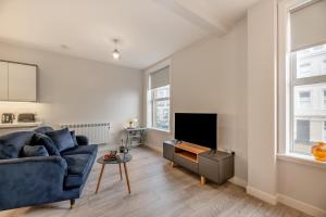 a living room with a blue couch and a tv at Hide Away in Berwick-Upon-Tweed