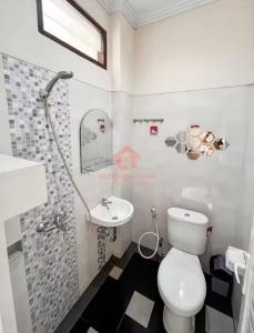 a bathroom with a toilet and a sink at Uluwatu Guest House C Pool & Wifi in Uluwatu