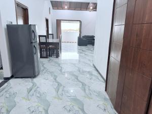 a hallway with a marble floor with a refrigerator at VILLA AAA WELIGAMA in Weligama