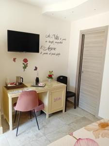 a room with a desk and a tv on the wall at Al Punto Giusto in Catania