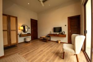 a living room with a chair and a television at Kevans Casa in Mahiyangana