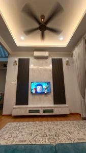 a living room with a ceiling fan and a flat screen tv at MA Homestay Kuala Nerus, Kuala Terengganu in Kuala Terengganu