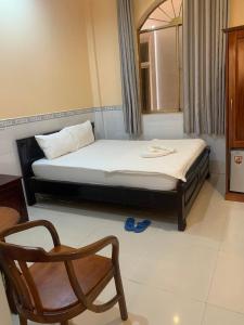 a bedroom with a bed and a chair in it at Nhà nghỉ TÂN MINH THOẠI in Phu Quoc