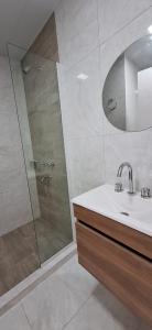 un bagno con doccia, lavandino e specchio di Vela Villa Apart a Villa Ángela Altre 52 foto