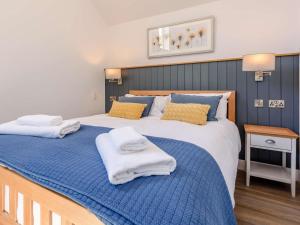 Un dormitorio con una cama grande con toallas. en 1 Bed in Woolacombe 82341, en Woolacombe