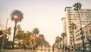 a group of people crossing a busy city street with palm trees at 2BR Condo in Santa Monica - Walking Distance to Beach, Dining, Shopping & Promenade in Los Angeles