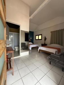 a hotel room with two beds and a bathroom at Finca San Antonio in Pluma Hidalgo
