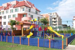 a playground with a slide in front of a building at Complex Apolon in Nesebar
