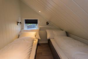 two twin beds in a small room with a window at Krøgeneslåven Microtel in Arendal +33 photos