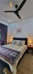 a bedroom with a bed with a ceiling fan at Villa Casablanca in Montongbuwoh