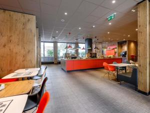 a restaurant with tables and chairs and a counter at ibis Mainz City in Mainz