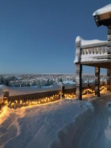 un banco cubierto de nieve con luces. en Log Cabin With Views Of Jotunheimen, en Hafjell
