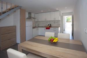 a kitchen with a table with a bowl of fruit on it at Mar e Sol Apartments in Hvar