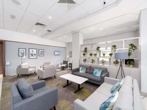 a waiting room with couches and chairs and a table at Novotel Southampton in Southampton
