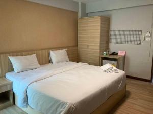 a bedroom with a large bed with white sheets at Station 203 Hotel in Min Buri