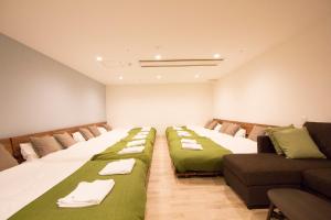 a room with three beds and a couch at SEVEN Building / Vacation STAY 4949 in Asahikawa +86 photos