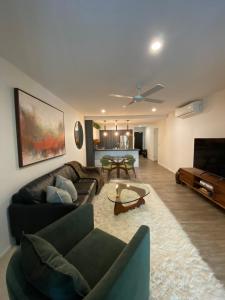 una sala de estar con un sofá y una mesa en Urban Retreat - Shared Apartment with Queen Bed and Private Ensuite, en Brisbane 5 fotos más