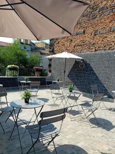a patio with tables and chairs and an umbrella at Al Punto Giusto in Catania