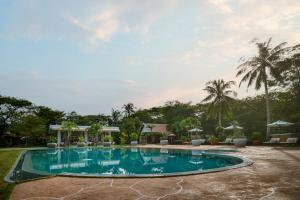 a pool at a resort with palm trees at Samanea Beach Resort & Spa in Kep