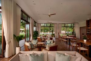 a living room with couches and tables and windows at Samanea Beach Resort & Spa in Kep
