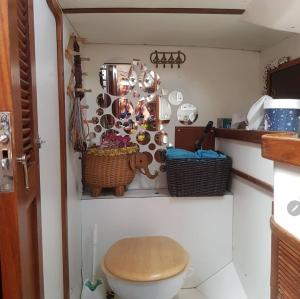a bathroom with a toilet and baskets on the wall at Paraty em um veleiro passeio diário in Paraty